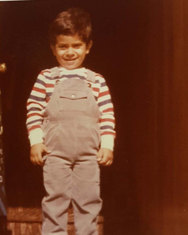 An old photo of a smiling five-year-old at the front door